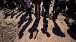 Migrants wait to be processed