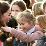 A young girl touches Princess Catherine's hair