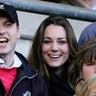 Princess Catherine and Prince William cheer from the stands at a football match.