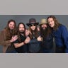 Brandon Still in a brown jacket stands next to Paul Jackson in a navy shirt and black vest, next to Charlie Starr with sunglasses and a big hat and Brit Turner with a big hat, and Richard Turner in a blue shirt