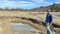 Farmer George Gross, of Dog River Farm in Berlin, Vt., stands, Wednesday, April 17, 2024, next to a hole left in his field by December, 2023, flooding. The farm lost nearly all of its produce in the catastrophic summer flooding that hit Vermont in July.