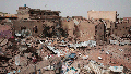 A man walks by a house hit in recent fighting in Khartoum, Sudan, Tuesday, April 25, 2023. Sudan has been torn by war for a year now, torn by fighting between the military and the notorious paramilitary Rapid Support Forces.