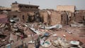 A man walks by a house hit in recent fighting in Khartoum, Sudan, Tuesday, April 25, 2023. Sudan has been torn by war for a year now, torn by fighting between the military and the notorious paramilitary Rapid Support Forces.