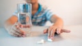 asian boy with cup of water and medicine in hand