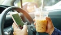 Driver holding ice coffee and mobile phone in car - Fox News
