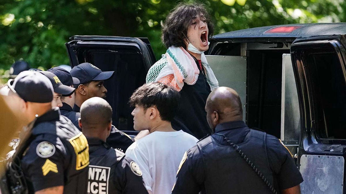 A protester yells as he gets loaded into a police van after being arrested during an anti-Israel protest against the war in Gaza at Emory University on April 25, 2024 in Atlanta, Georgia, amid the Israel-Hamas war.