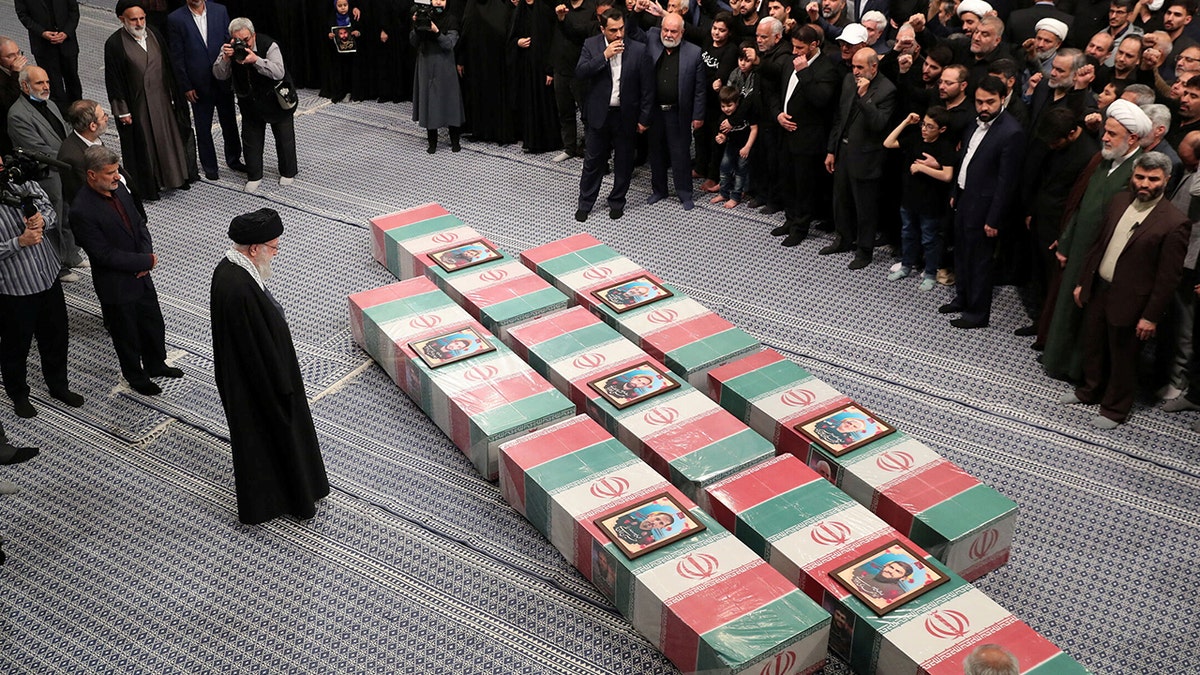 Ayatollah Ali Khamenei looking astatine coffins