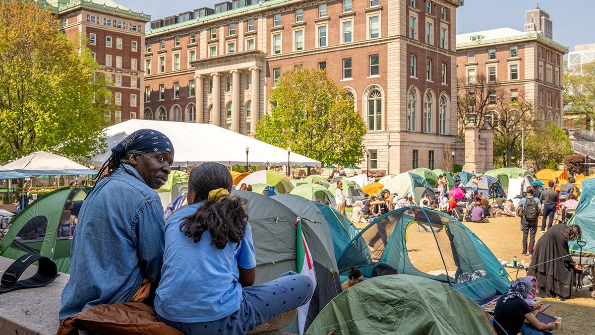 Students sitting by tents
