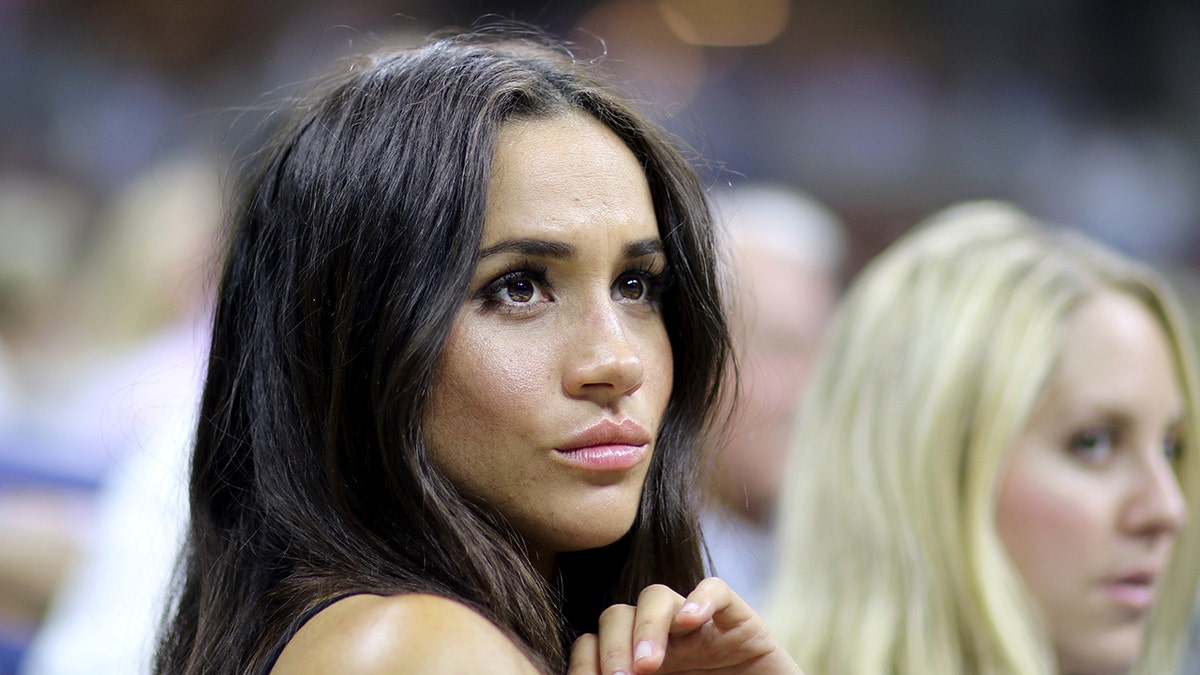 Meghan Markle looking serious in a crowd