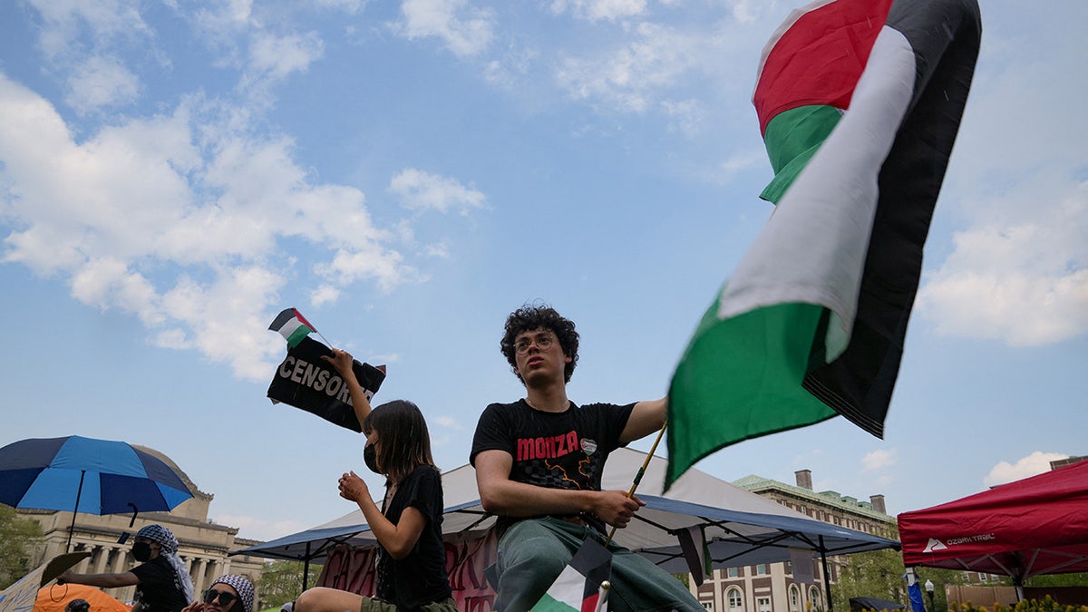 man waves Palestinian emblem astatine Columbia University rally