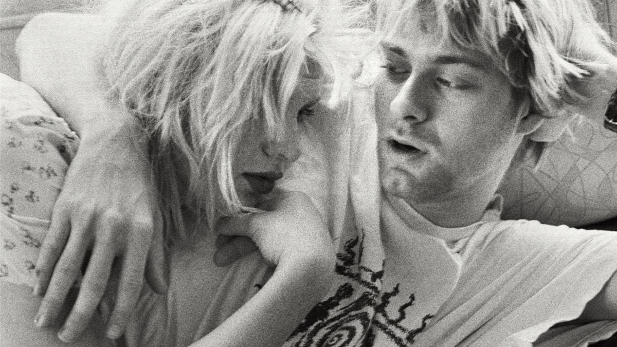 A black and white photo of Kurt Cobain and Courtney Love hugging