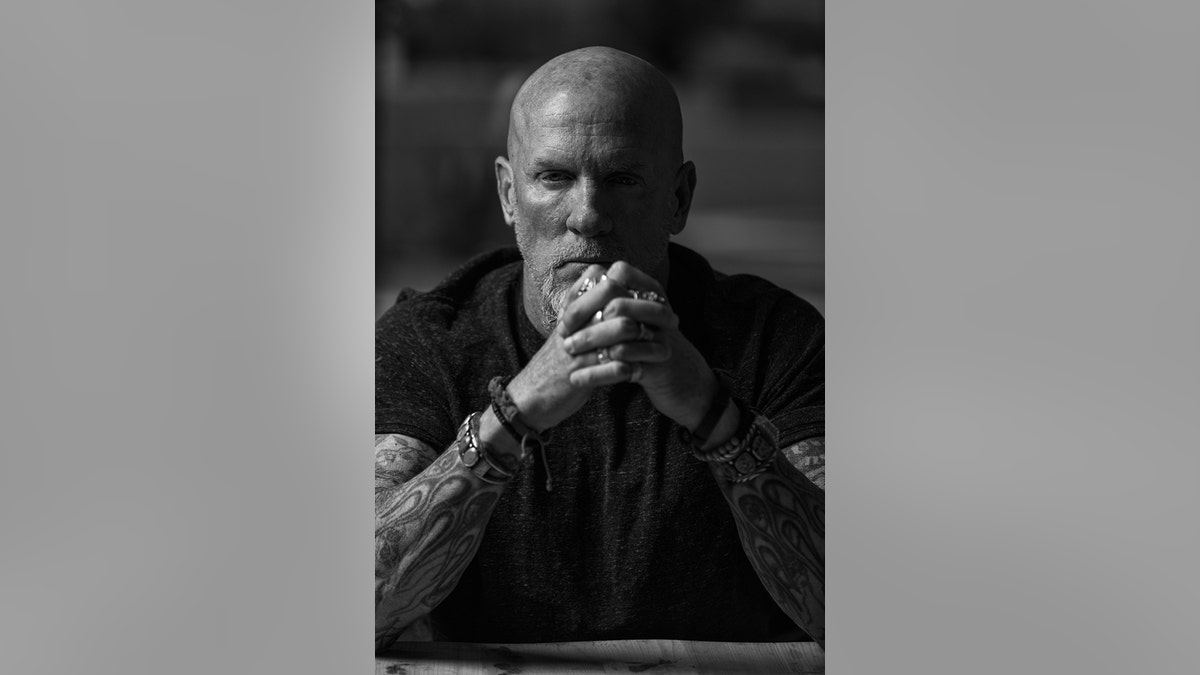 A black and white portrait of Jay Dobyns looking serious