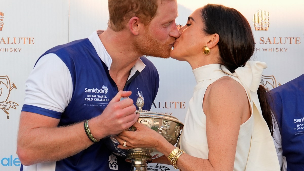 Príncipe Harry e Meghan Markle se beijam após uma partida beneficente de pólo.