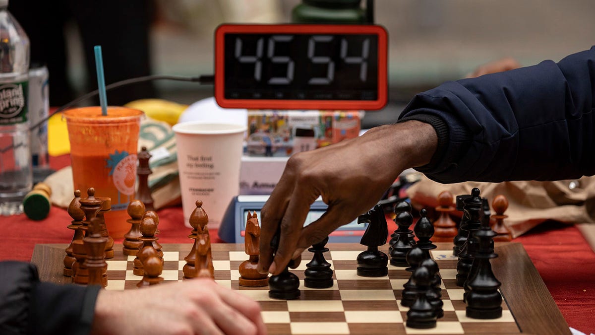two hands playing chess successful beforehand of a clock