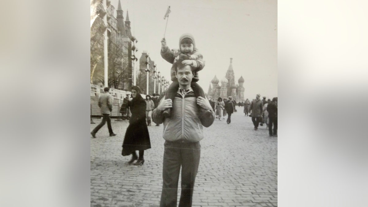 Aliia Roza as a child on the shoulders of her father