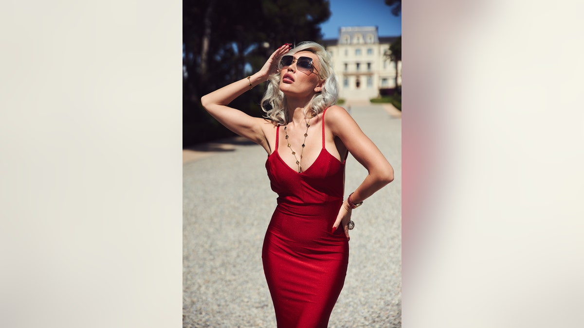 Aliia Roza posing in a red dress