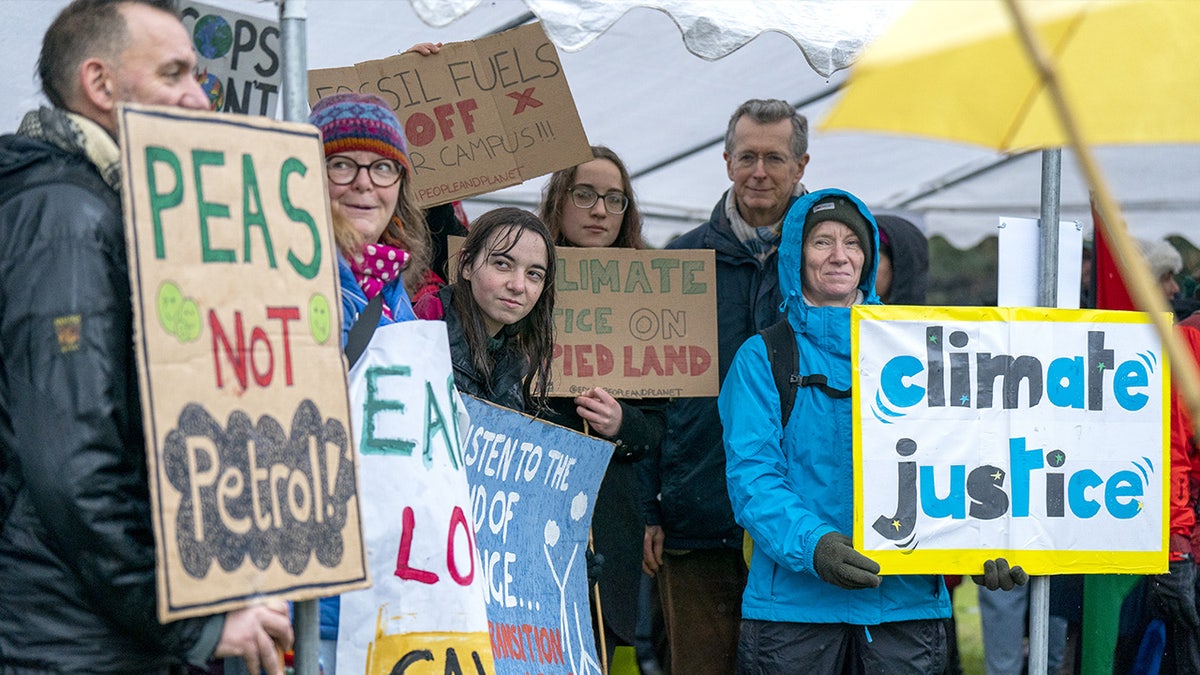 Climate protesters clasp signs during a march