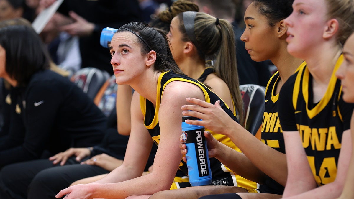 Caitlin Clark leans over on bench