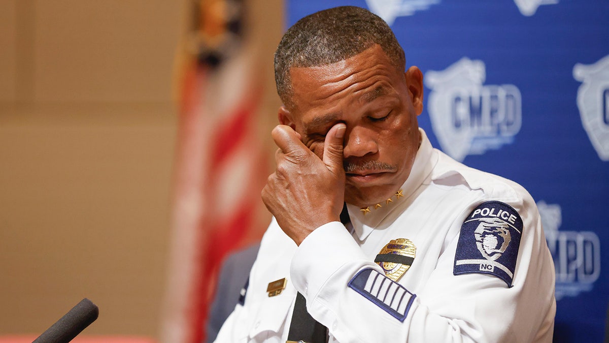 Police Chief Johnny Jennings wipes away tears as he speaks at a press conference