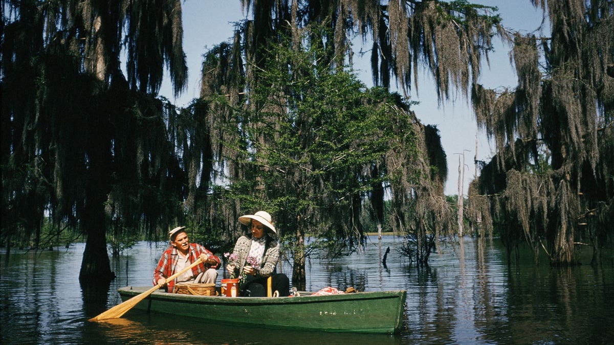 A couple picnics in a canoe in the Chicot State Park