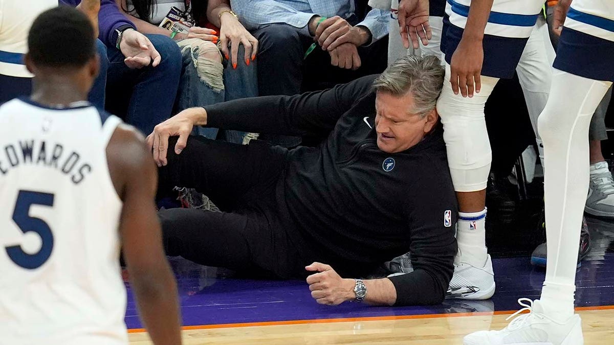 Chris Finch holds his knee after colliding with Timberwolves guard Mike Conley during the second half of Game 4 of an NBA first-round playoff series against the Phoenix Suns April 28, 2024, in Phoenix.