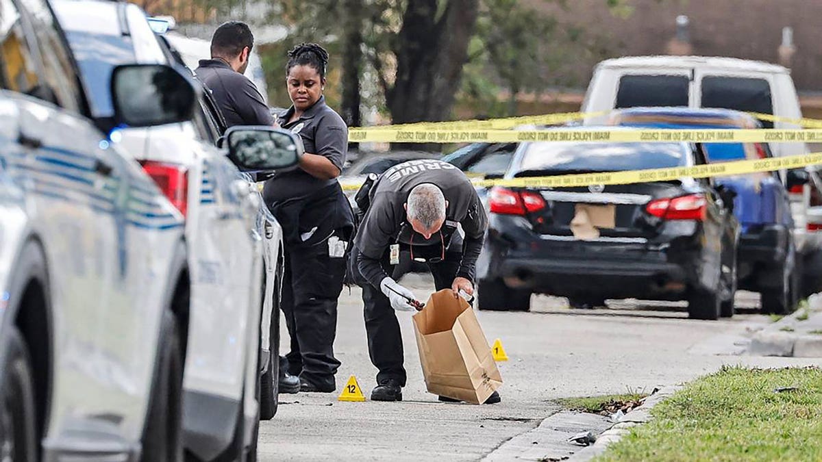 Miami crime scene investigators gather evidence after police shot a man near Northwest Seventh Court and 57th Street in Miami.
