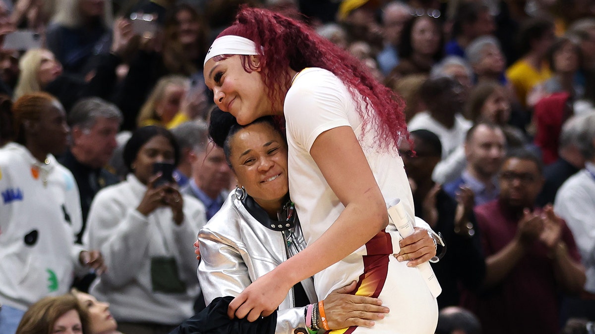 Kamilla Cardoso celebrating with head coach Dawn Staley on basketball court