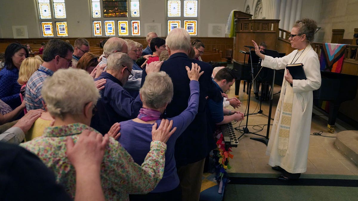 The Rev. Tracy Cox of First United Methodist Church and members of her congregation pray