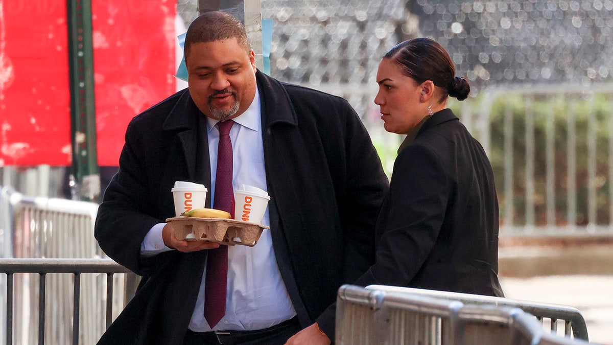 Manhattan district attorney Alvin Bragg holding coffees