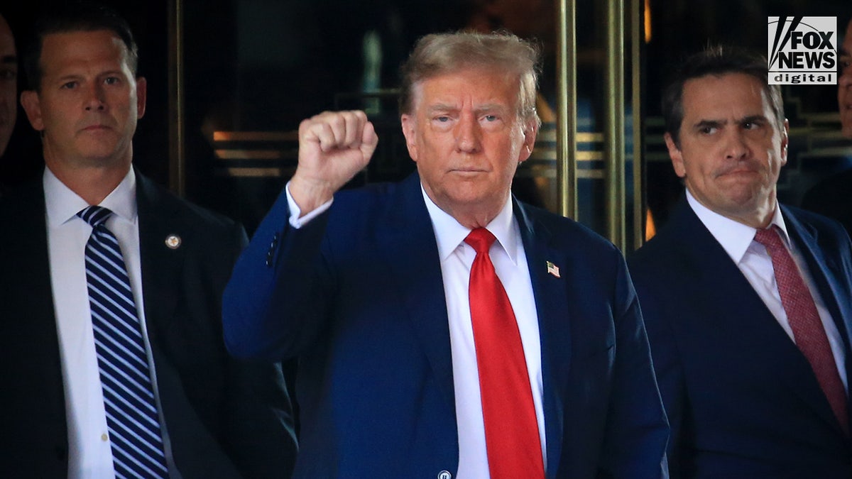 Former President Trump pinch correct fist raised, leaving Trump Tower 