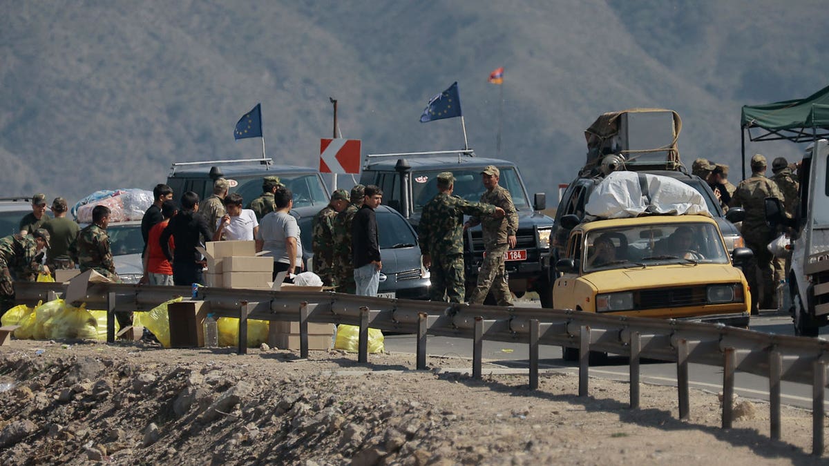 Ethnic Armenians from Nagorno-Karabakh and European Union observers drive their cars past a check point on the road from Nagorno-Karabakh to Armenia's Goris in Syunik region, Armenia.