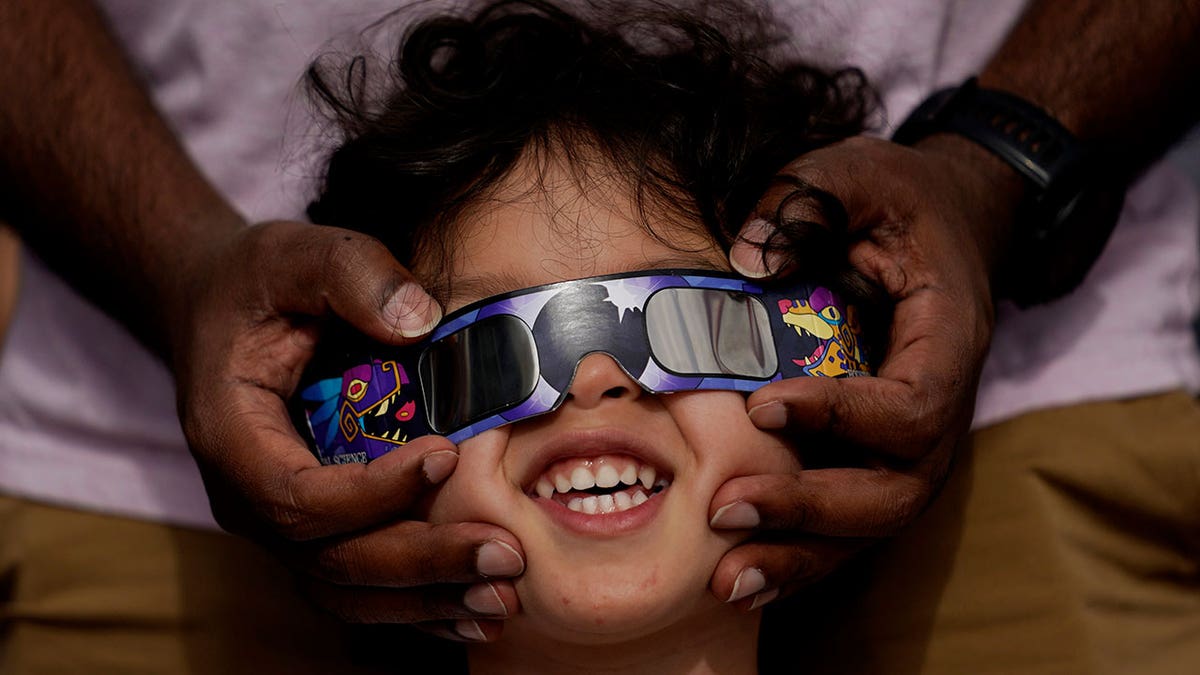 Child wearing eclipse glasses