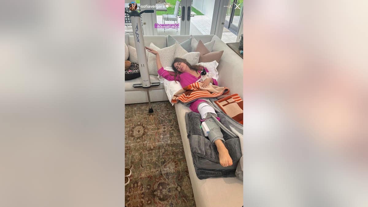 Sofia Vergara deitada no sofá com joelheira