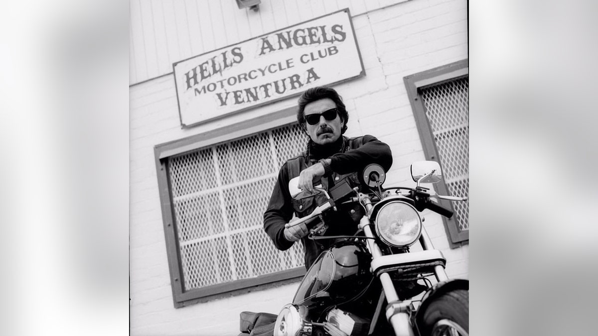 George Christie sitting on a motorcycle posing in front of the Hells Angels Motorcycle Club in Ventura