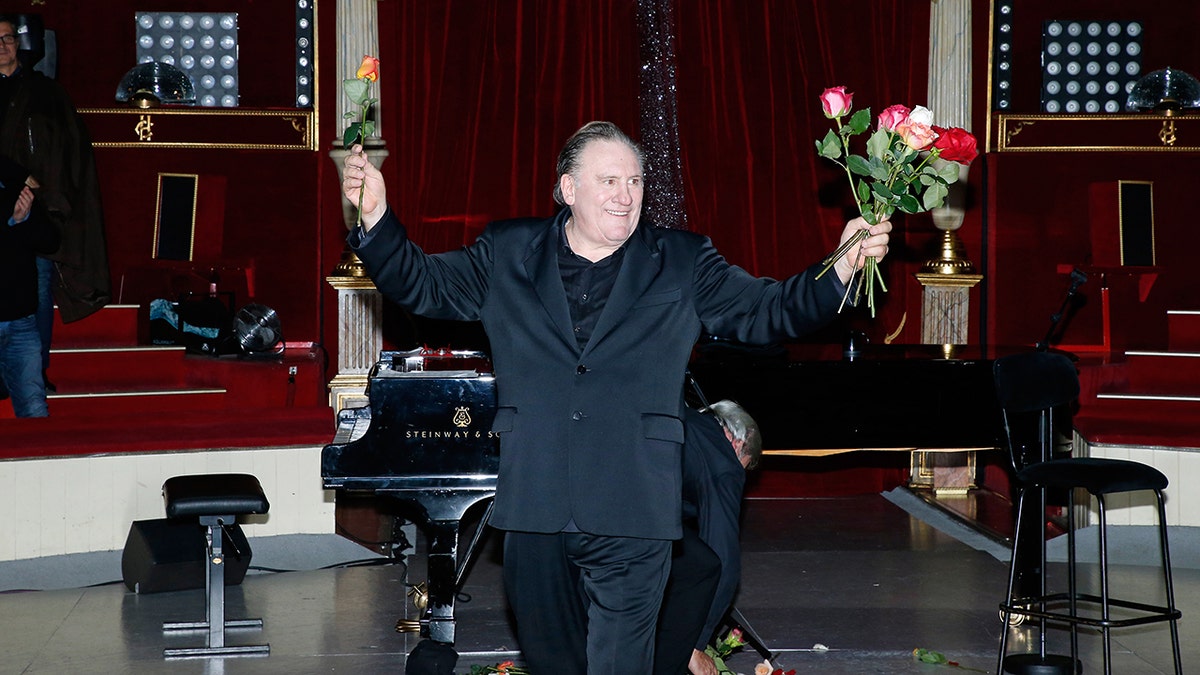 Gerard Depardieu holds flowers connected stage