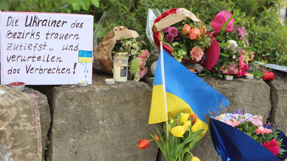 Flowers and a small Ukrainian flag are laid at a shopping center in Murnau, Germany, Sunday, April 28, 2024.