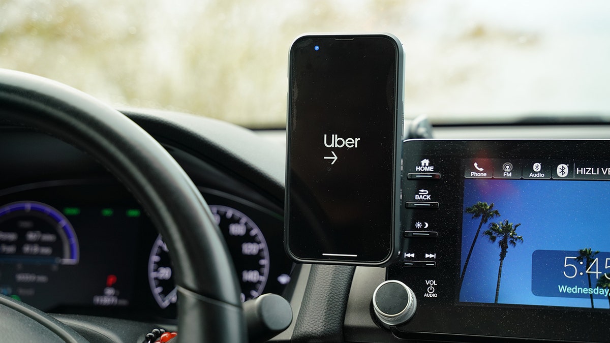 aplicativo uber aberto no painel de um carro