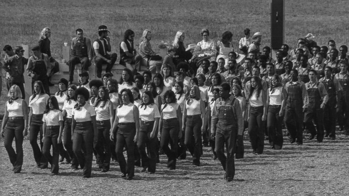 A group of Synanon members wearing the same uniforms march in straight lines