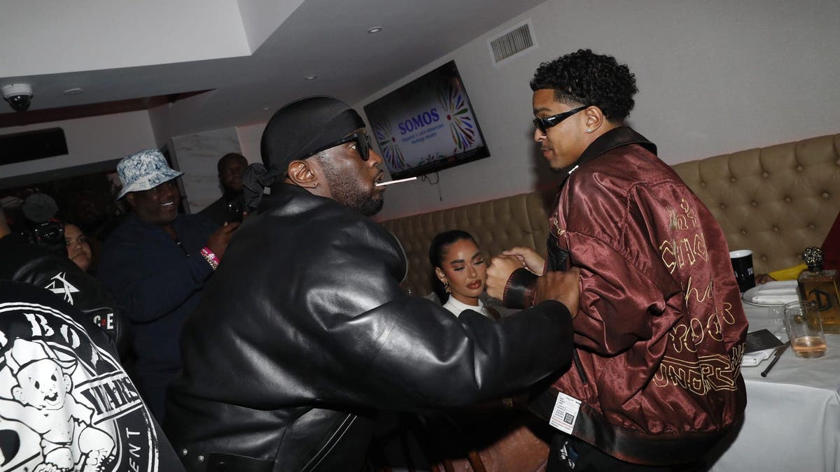 Diddy and Juston Combs shake hands at a party