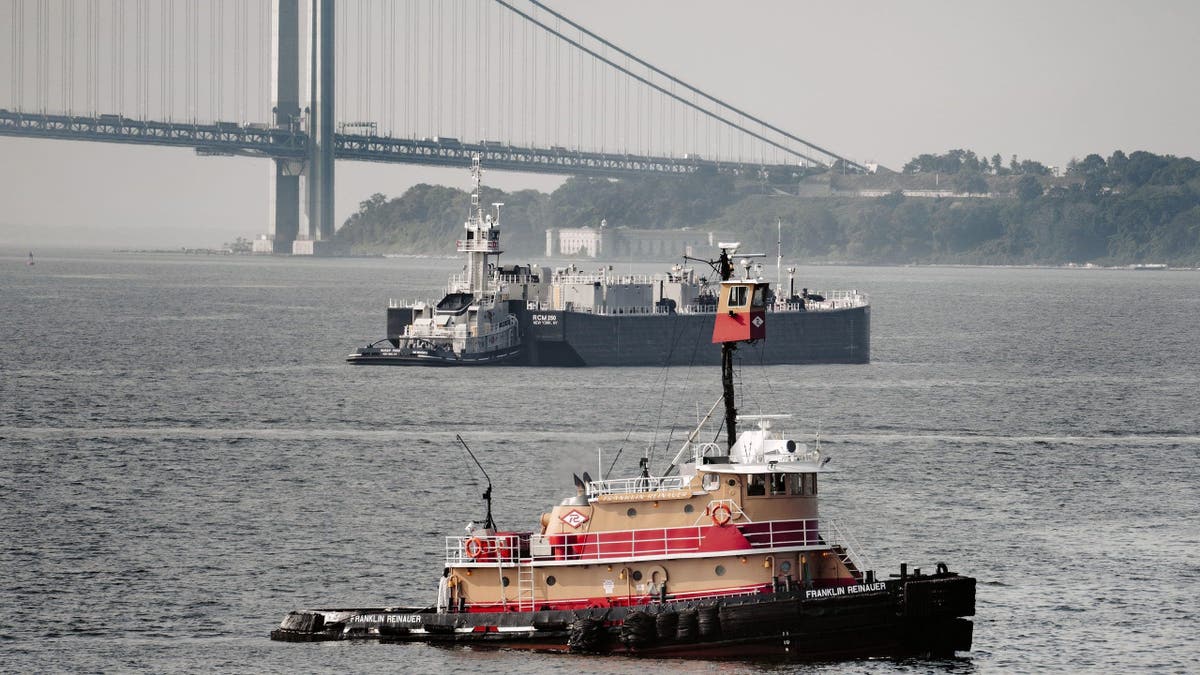 Tugboat and barge in upper New York Bay with Verrazzano-Narrows Bridge and Staten Island in background< New York City, New York, USA