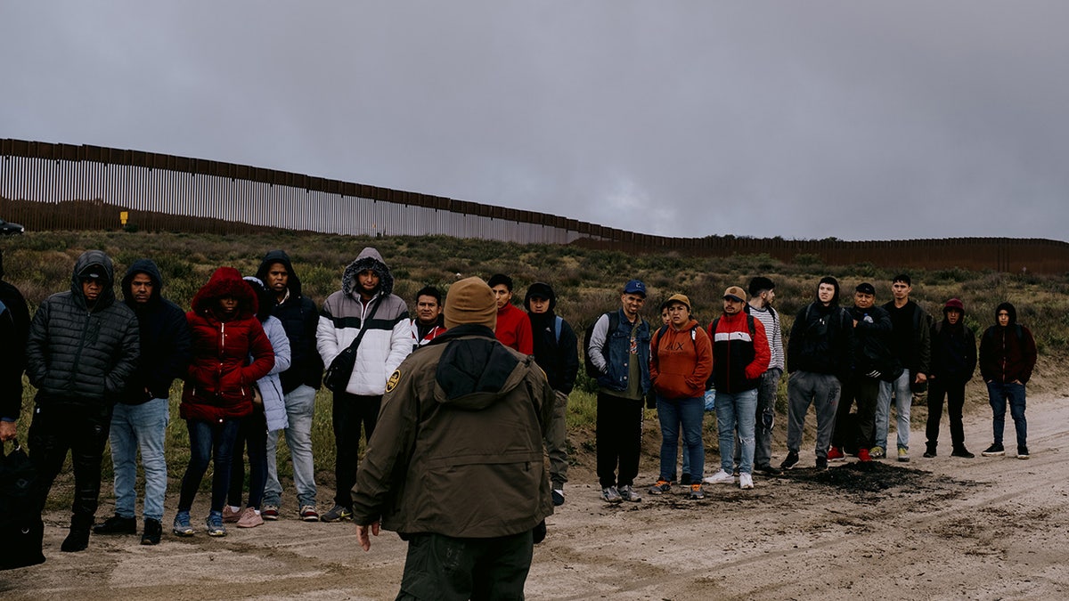 Border Patrol stops migrant by wall