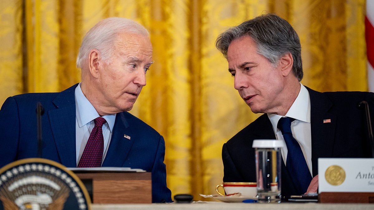 Biden and Blinken speak to each other during a summit