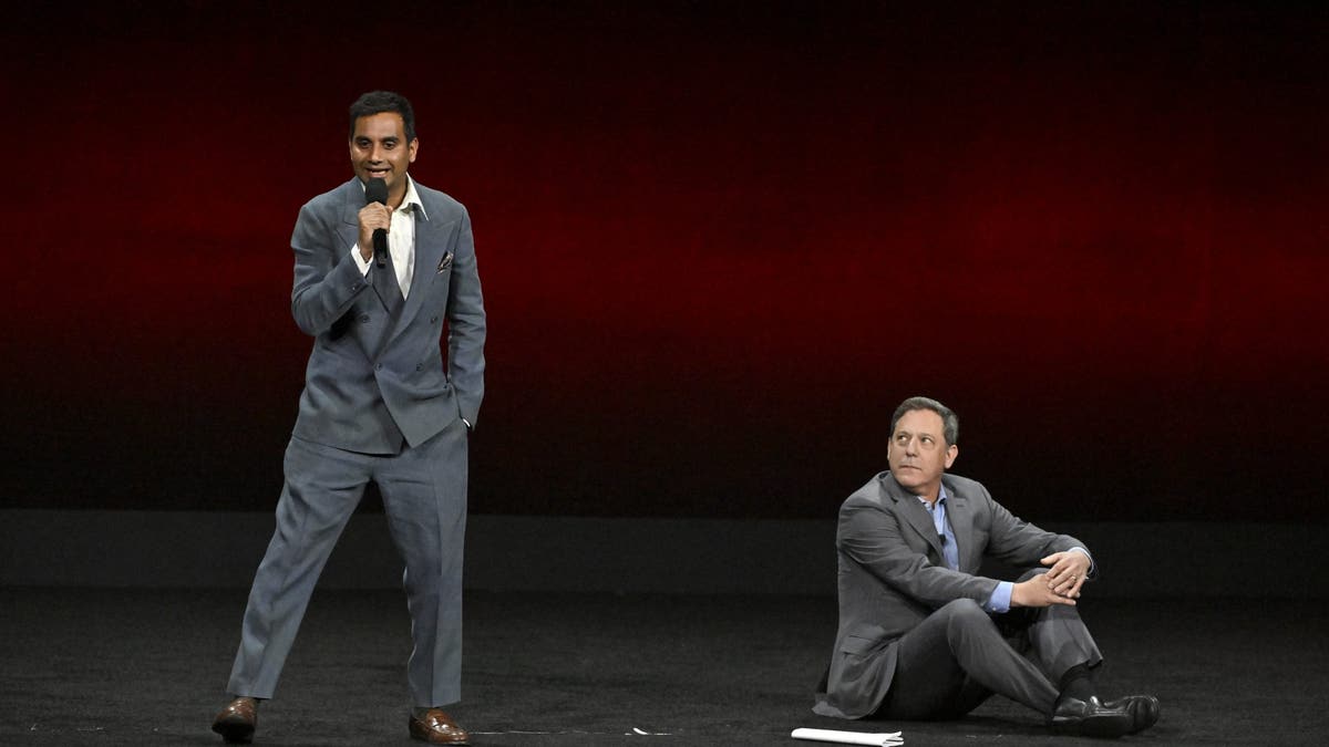 Aziz Ansari no palco com Adam Fogelson no Cinemacon