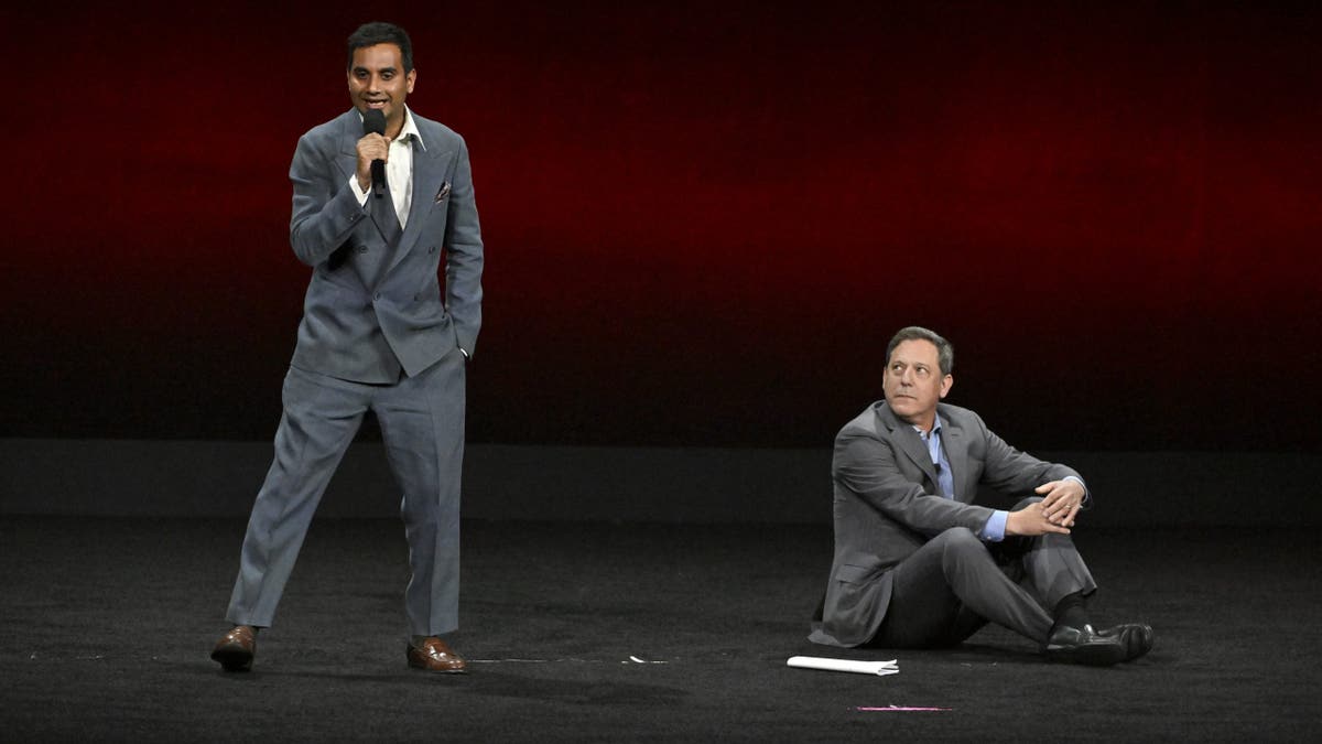 aziz ansari on stage with adam fogelson at cinemacon