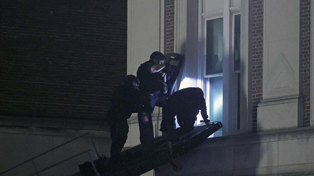 NYPD officers in riot gear break into a building at Columbia University, where pro-Palestinian students are barricaded inside a building and have set up an encampment, in New York City on April 30, 2024. 