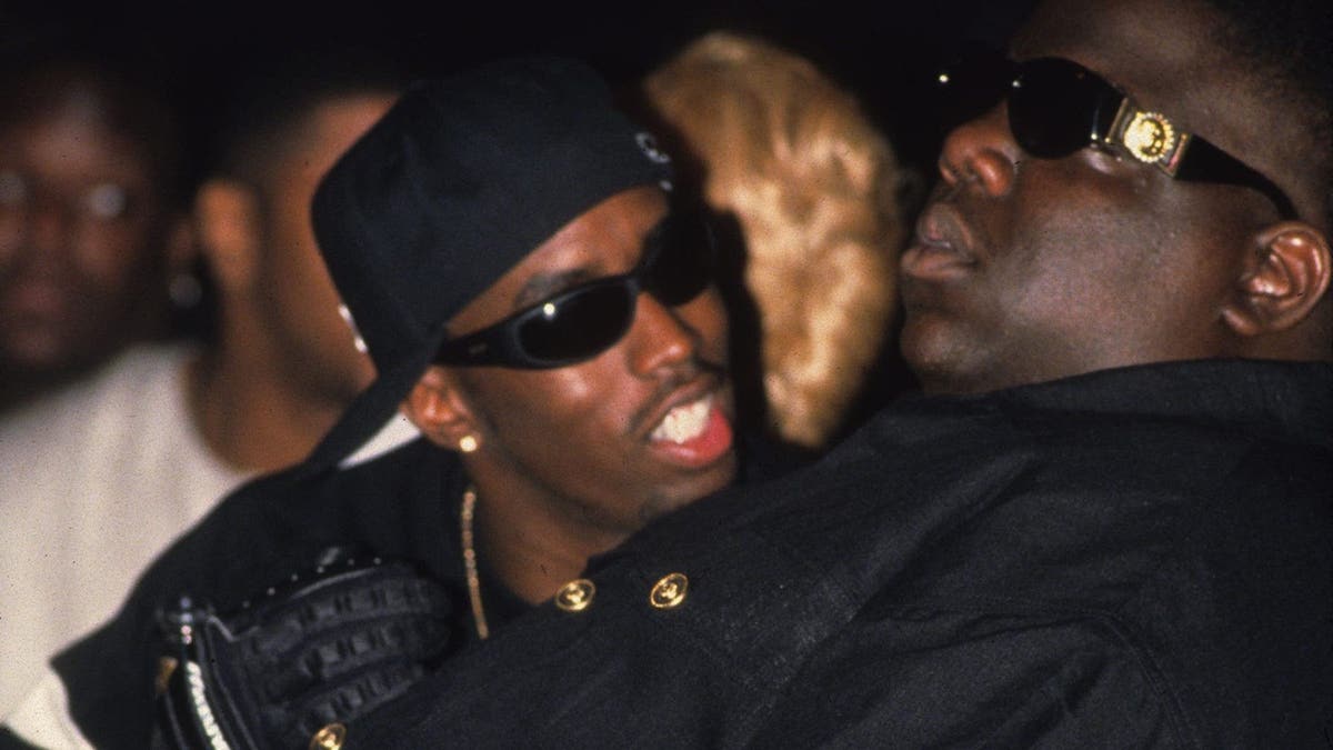Diddy, then known as Puff Daddy, speaks with Notirous B.I.G. while seated in the audience of the 1995 Source Awards