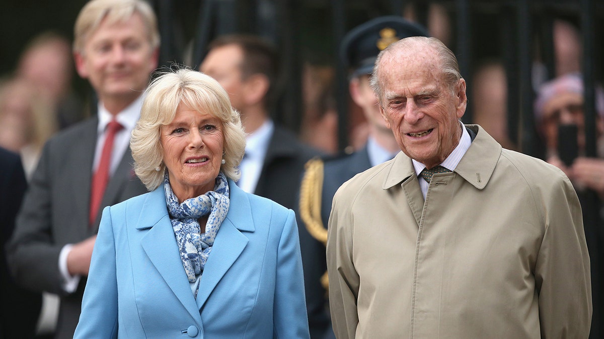 Camilla wearing a powder bluish overgarment opinionated adjacent to Prince Philip successful a beige trenchcoat