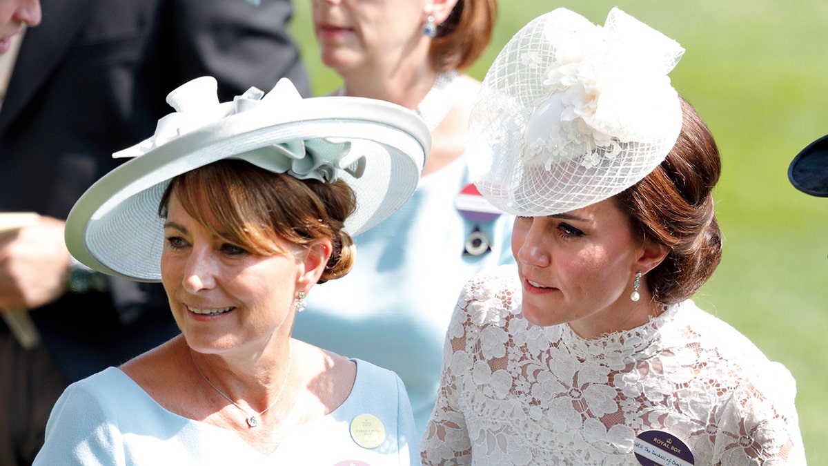 Carole Middleton e Kate Middleton usando vestidos e chapéus rendados