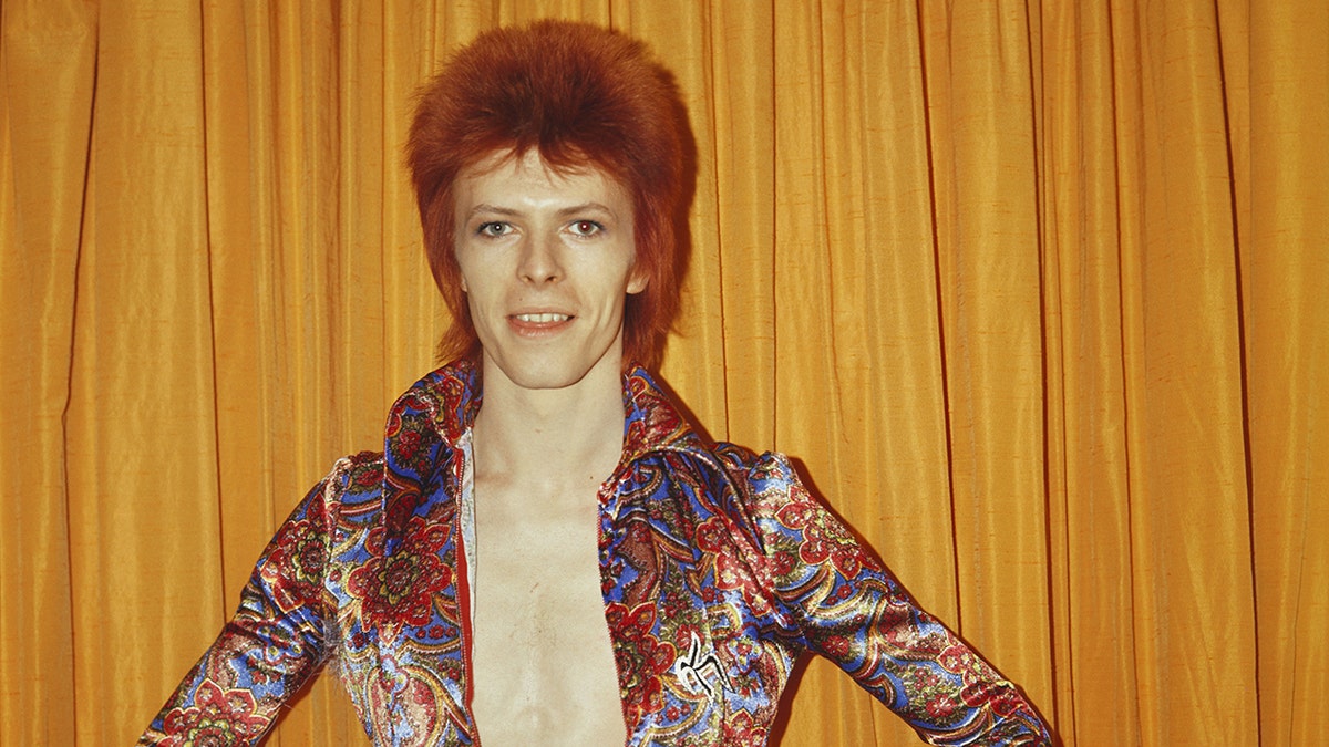 A close-up od David Bowie wearing a colorful blouse