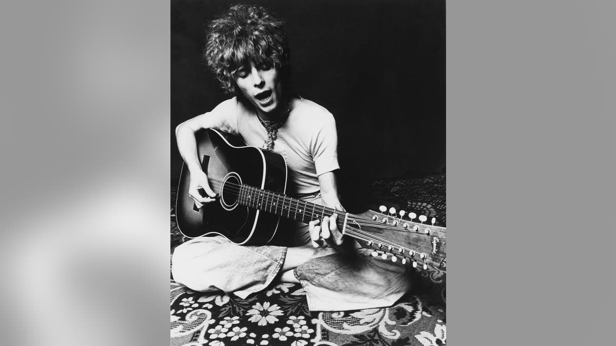 David Bowie playing guitar